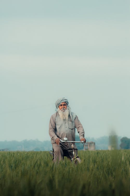 Village man posing with his cycle inside paddy field