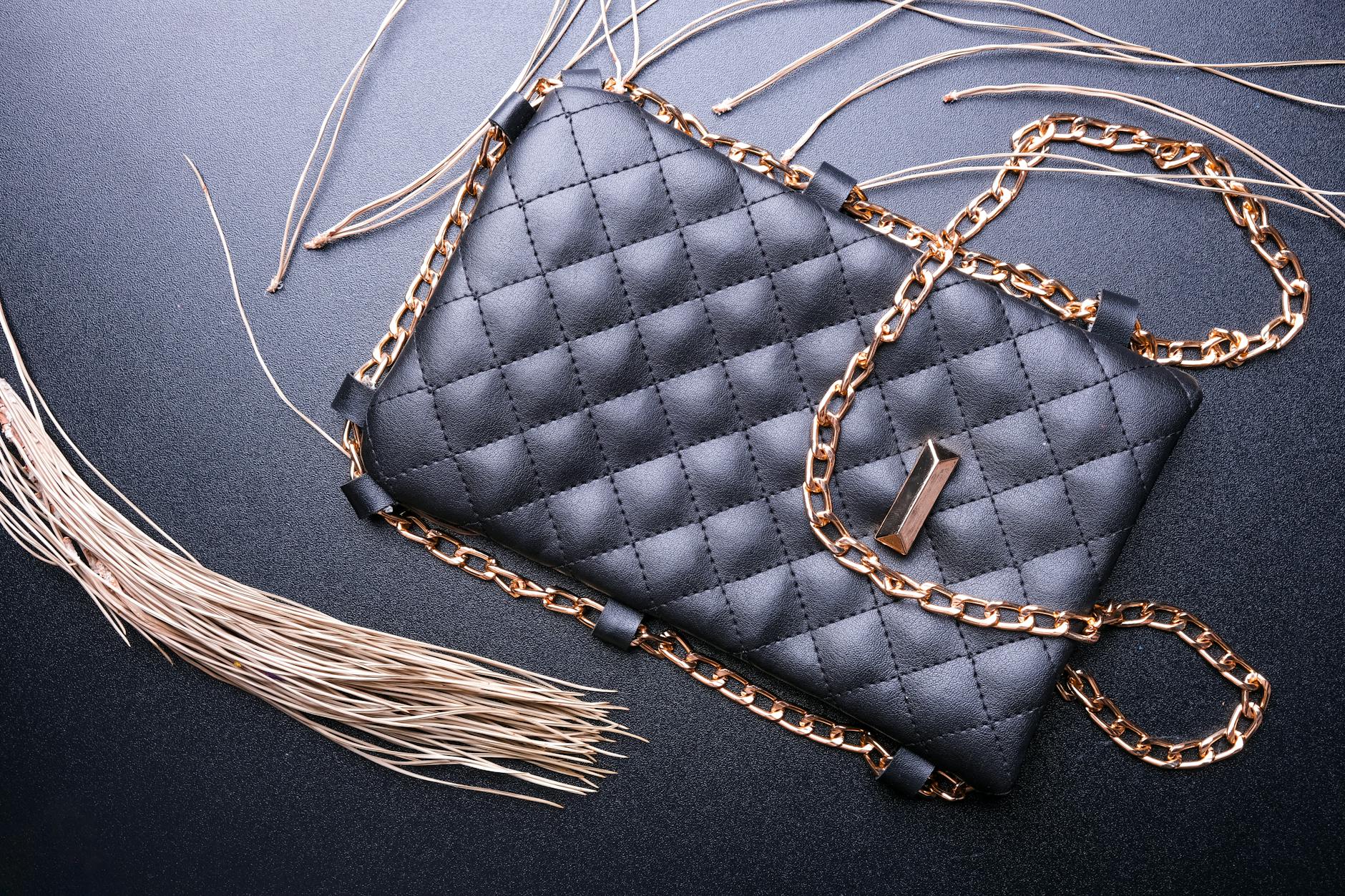 Stylish black purse with a quilted pattern and golden chain strap, showcasing elegance.