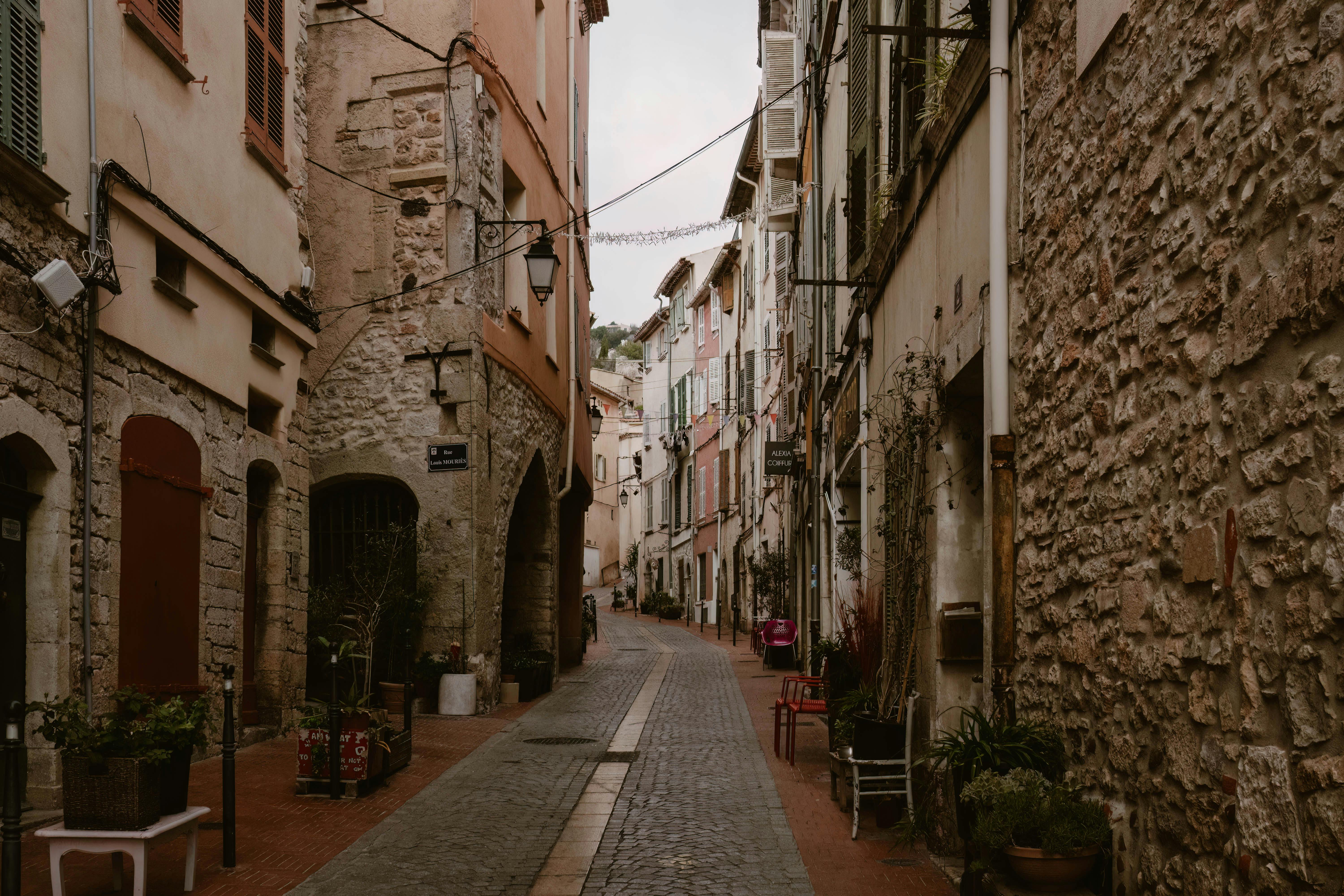 Explore a quaint cobblestone street in Le Revest-les-Eaux, Provence, capturing rustic architecture.