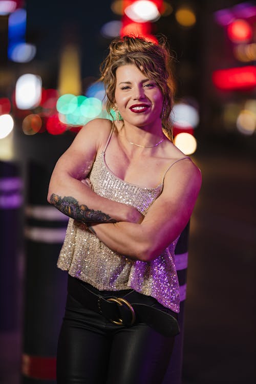 A woman in leather pants and a tank top posing for a photo