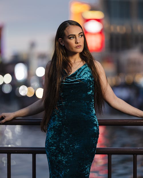 A woman in a blue velvet dress posing for a photo