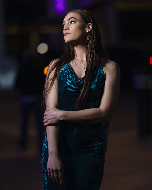 A woman in a blue dress standing in the middle of the street