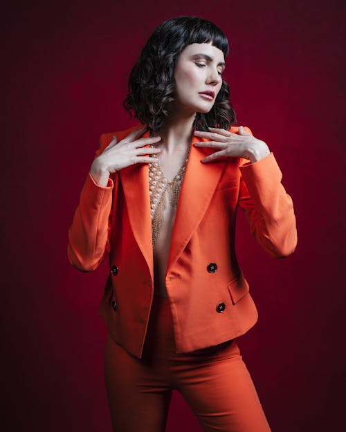 A woman in an orange suit posing for a photo