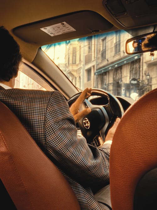 A man driving a car with a man in a suit