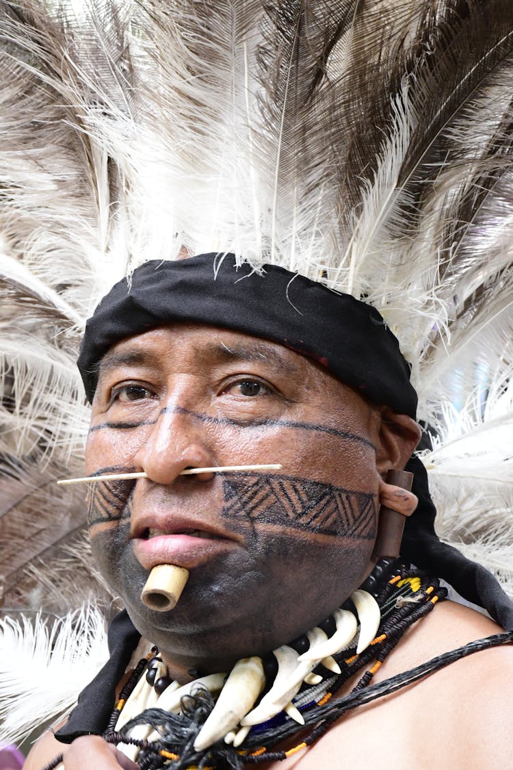 Man In Plume And With Tattoo And Piercing On Face