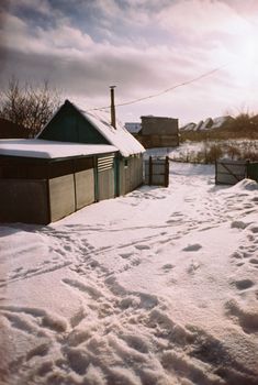 Charming rural scene with snow-covered houses in a peaceful winter landscape.