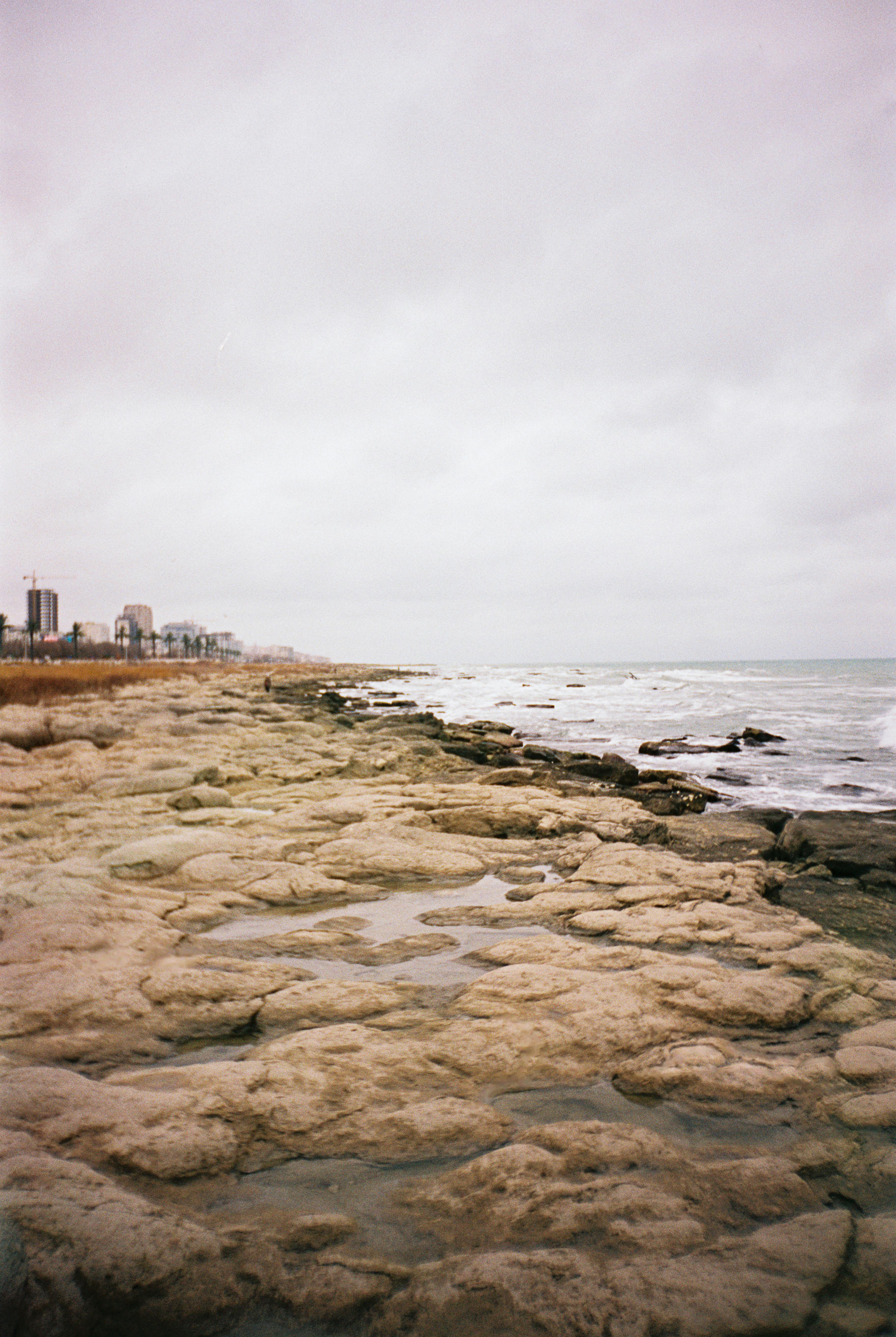Scenic coastal view in Aktau, Kazakhstan showcasing rocky terrain and Caspian Sea waves.
