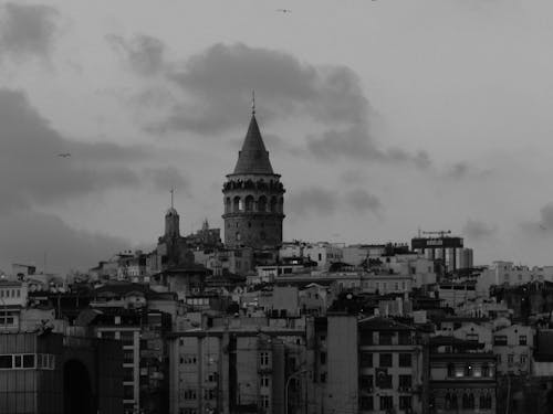 A black and white photo of a city with a tower