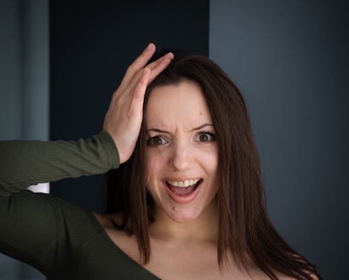 A woman is making a funny face with her hands