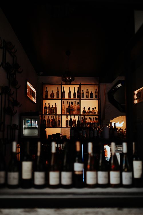 Free Dimly lit bar in Alaçatı, İzmir featuring a collection of liquor bottles on shelves. Stock Photo