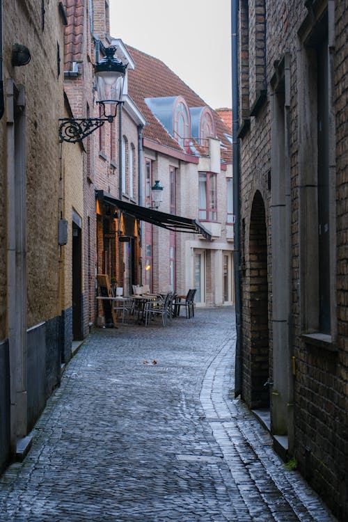 A narrow street with cobblestones and a brick building