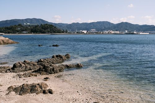 Free Serene seaside landscape of Gamagōri with lush hills and calm waters. Stock Photo