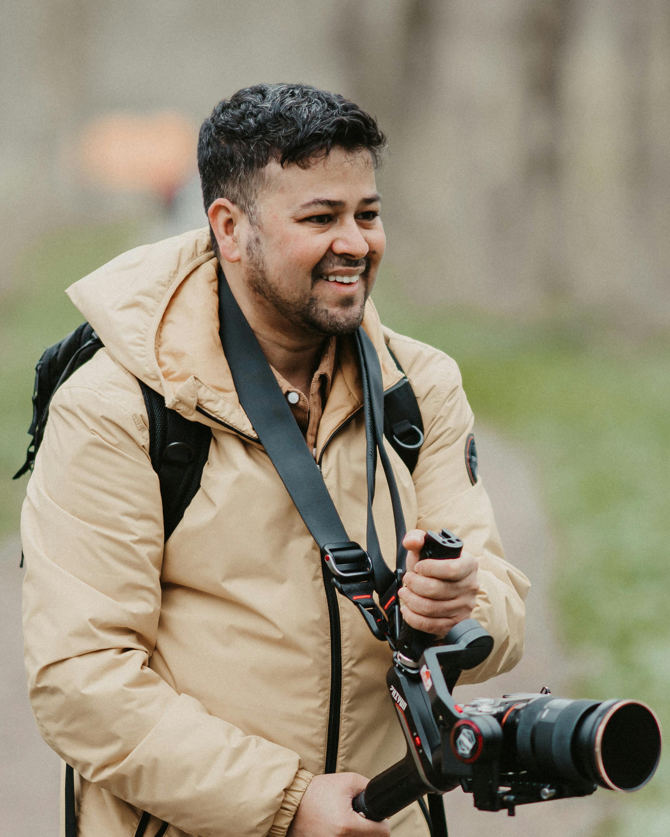 smiling photographer in a beige jacket