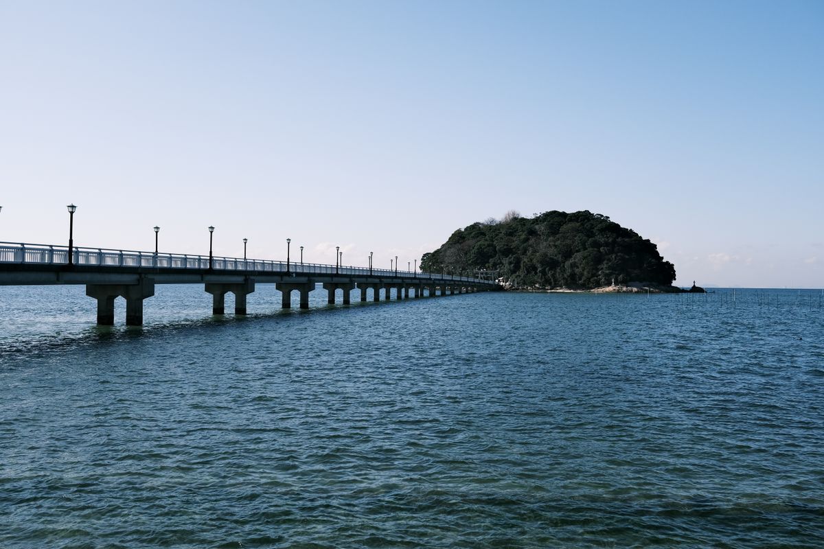 Coastal view with a bridge connecting a small island, similar to the scenery around Sado Island in Niigata
