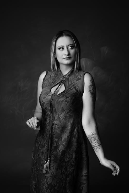 A woman in a dress with tattoos on her arm