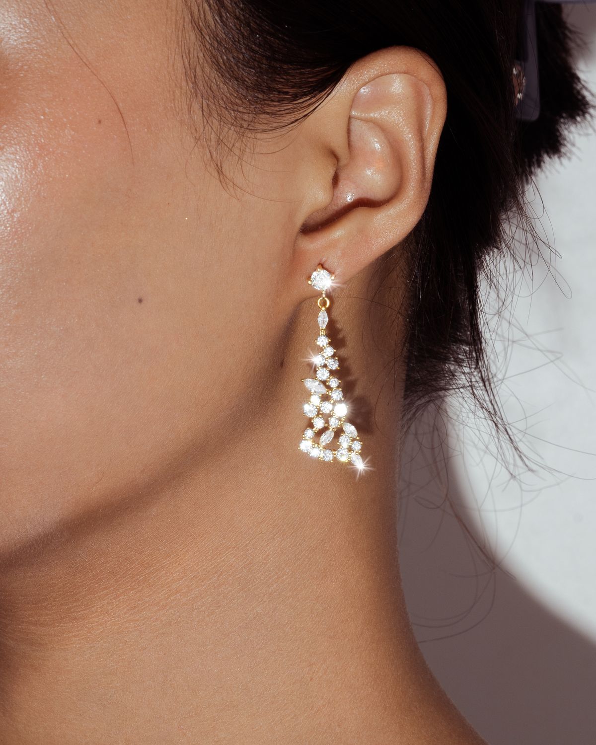Diamond earring worn on an ear to show real-life scale and everyday appearance