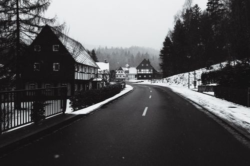 Free A serene winter scene featuring a snowy road winding through the picturesque village of Jonsdorf, Germany. Stock Photo
