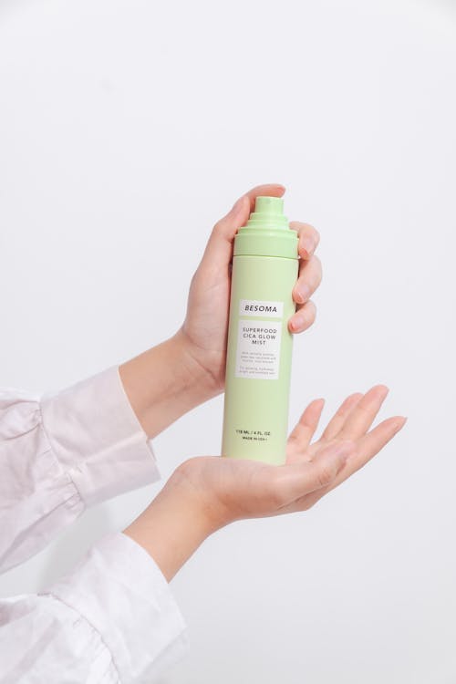 Pair of Hands Holding a Skincare Spray Bottle