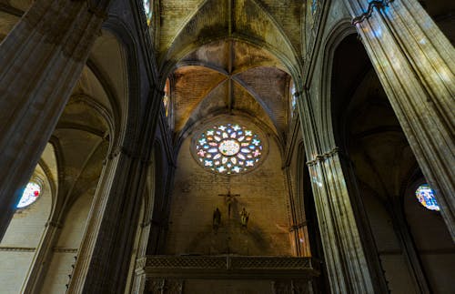 A stained glass window in a cathedral with a large cross