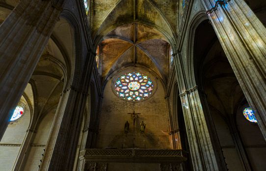 Low angle of Seville Cathedral's gothic architecture with stunning stained glass.