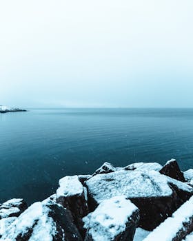 特隆斯特冬日宁静，白雪覆盖的岩石点缀着平静的海边