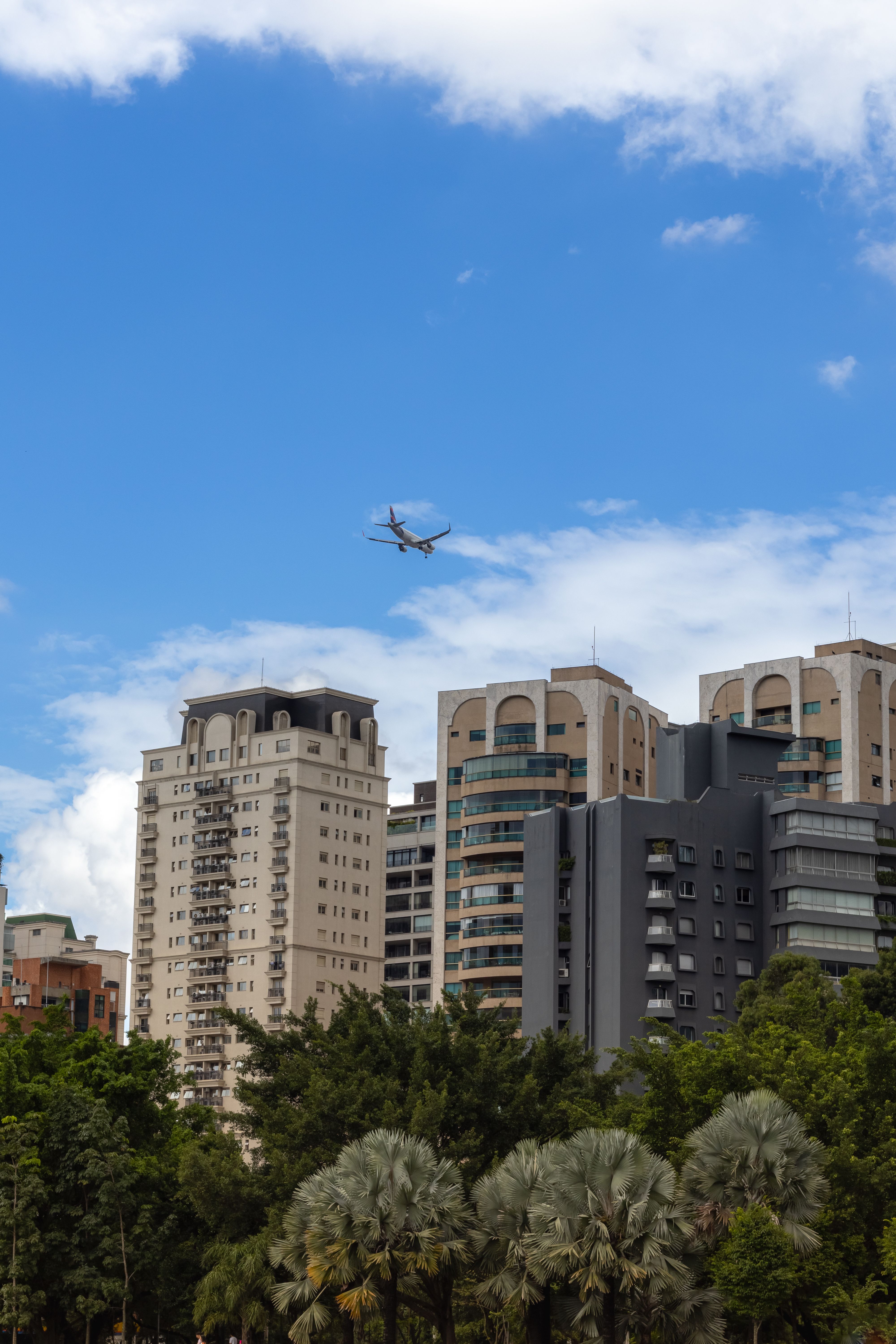 Airplane Flying over Residential Buildings in City · Free Stock Photo