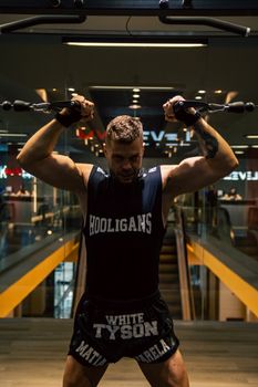 A strong man engages in an intense workout session using gym equipment, exhibiting strength and determination.