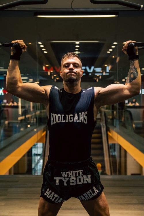 Free A strong male athlete working out in a modern gym, focusing on lifting weights with determination. Stock Photo