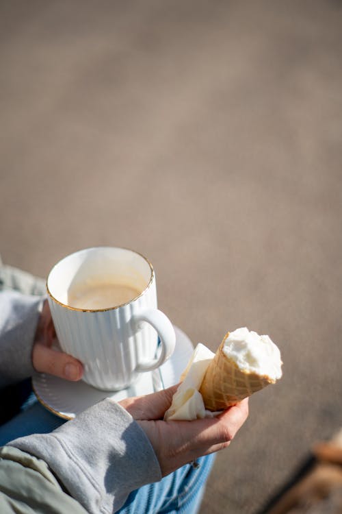 A Person with a Coffee and an Ice-Cream Cone