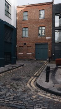 Charming urban street with cobblestone, brick buildings, and vintage ambiance.