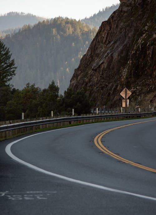 A road with a sign on it and a mountain in the background