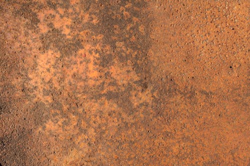 A rusty metal surface with some dirt on it
