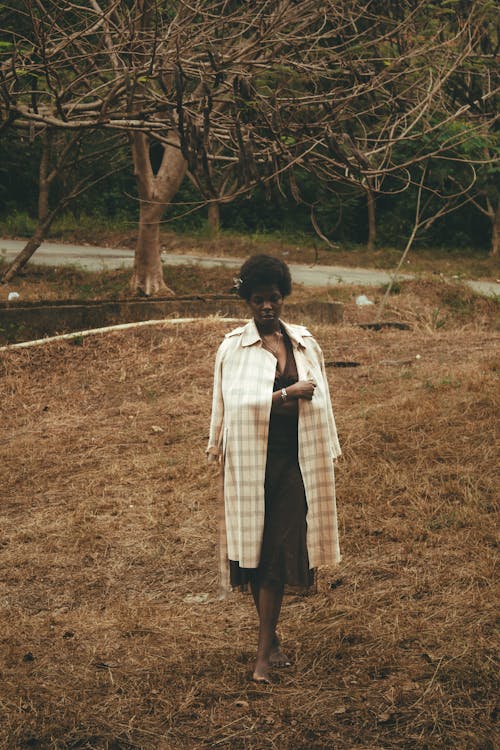 A woman in a long coat standing in a field