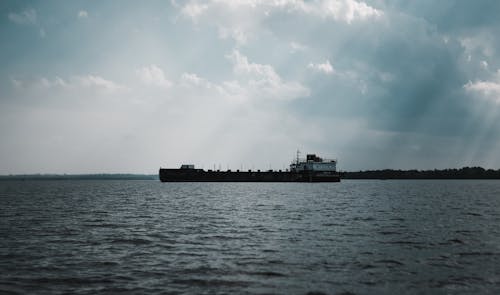 Ship Sailing Under Cloudy Sky