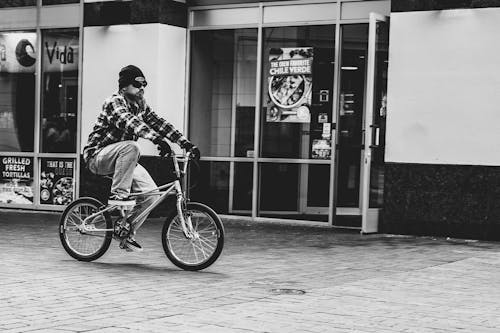 Grayscale Photography Of Man Riding Bike