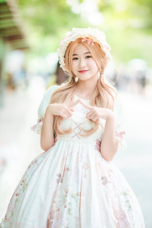 A young woman in a dress and hat posing for a photo