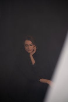 A serene portrait of a woman in elegant black clothing, captured in a studio setting.