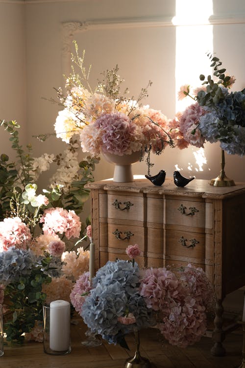 A room with flowers and vases on a table
