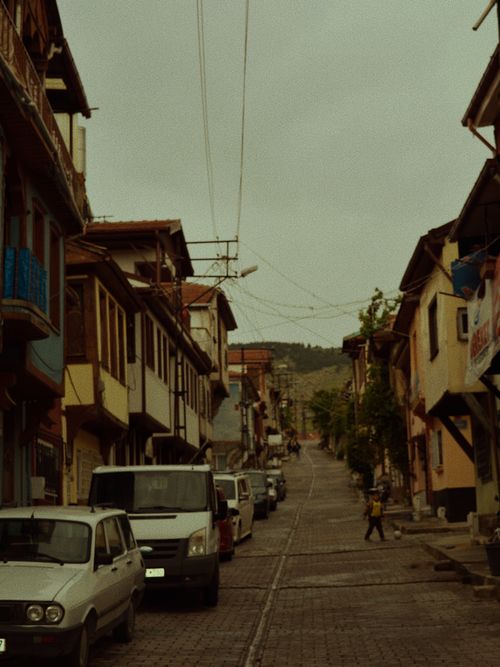 Free Scenic view of a quaint urban street with vintage architecture and parked cars. Stock Photo