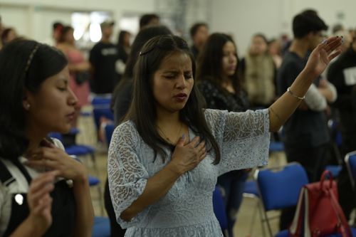 Free People engaged in prayer and worship in a religious gathering in Mexico City. Stock Photo