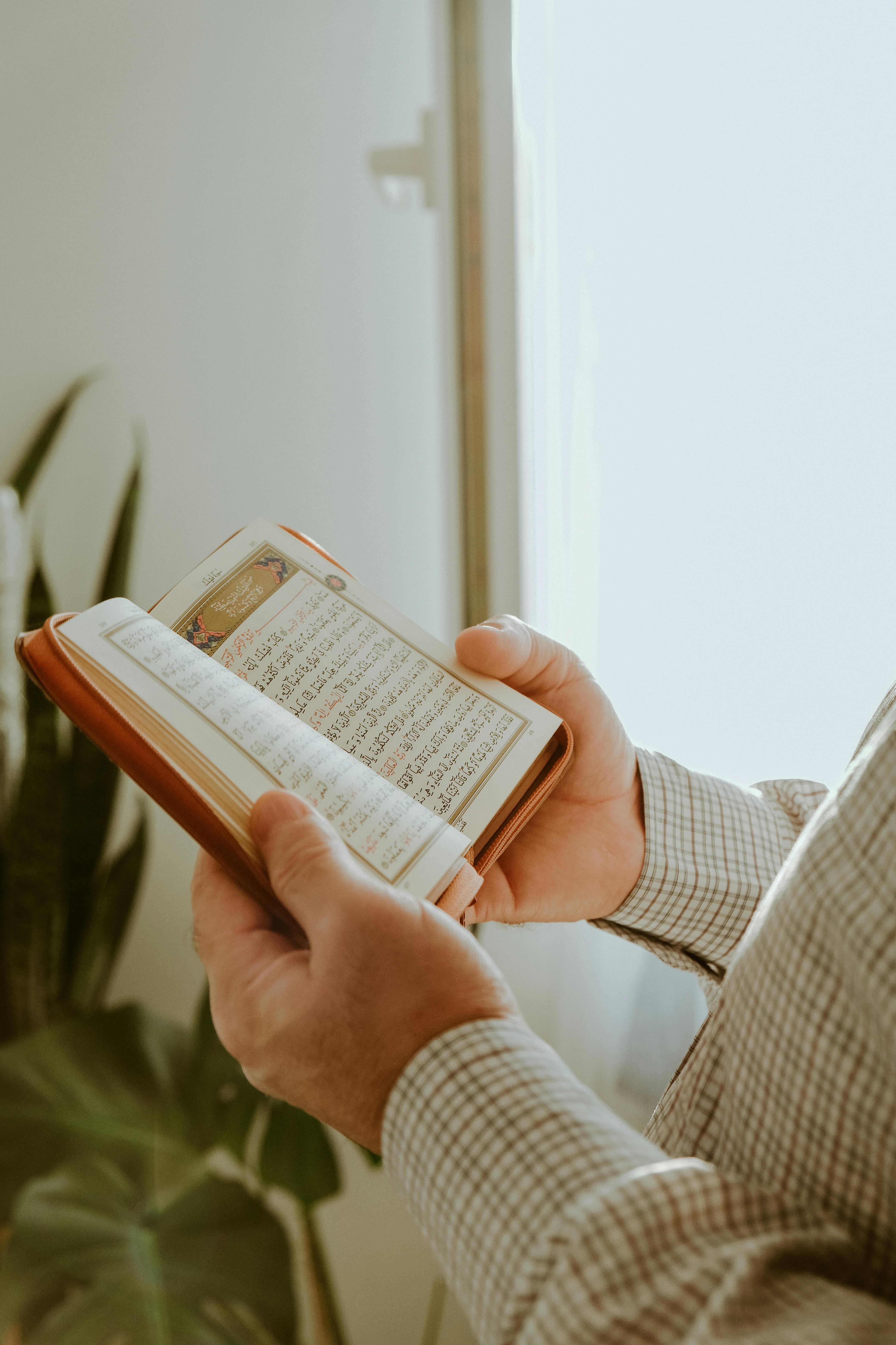 man hands holding koran