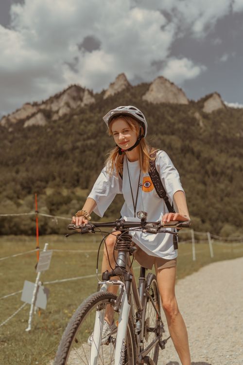 Free Adult woman cycling on a dirt road in the scenic rural area of Sromowce Niżne, Małopolskie, Poland. Stock Photo