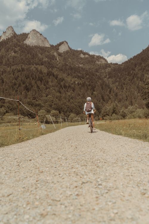 Free Cyclist biking on a gravel path in the scenic Pieniny Mountains, Poland during summer. Stock Photo