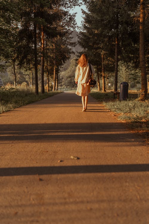 A woman walking down a road in the woods
