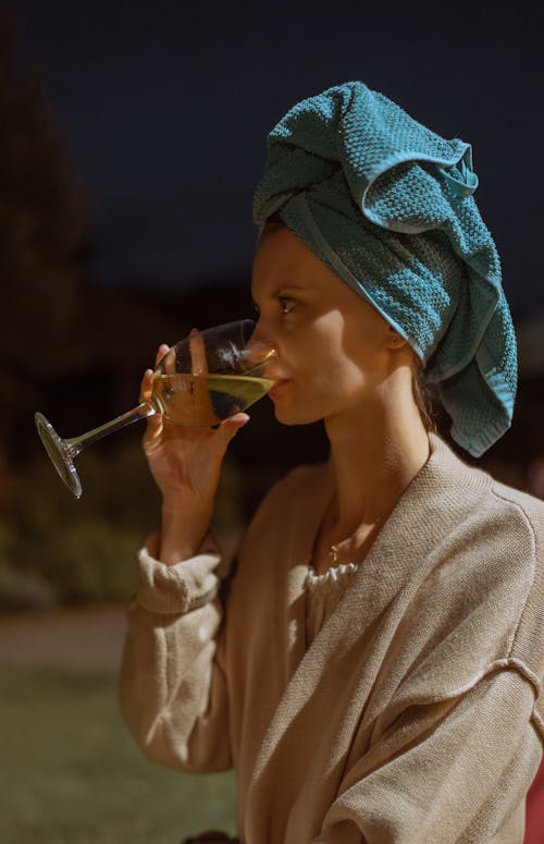 A woman in a turban drinking wine