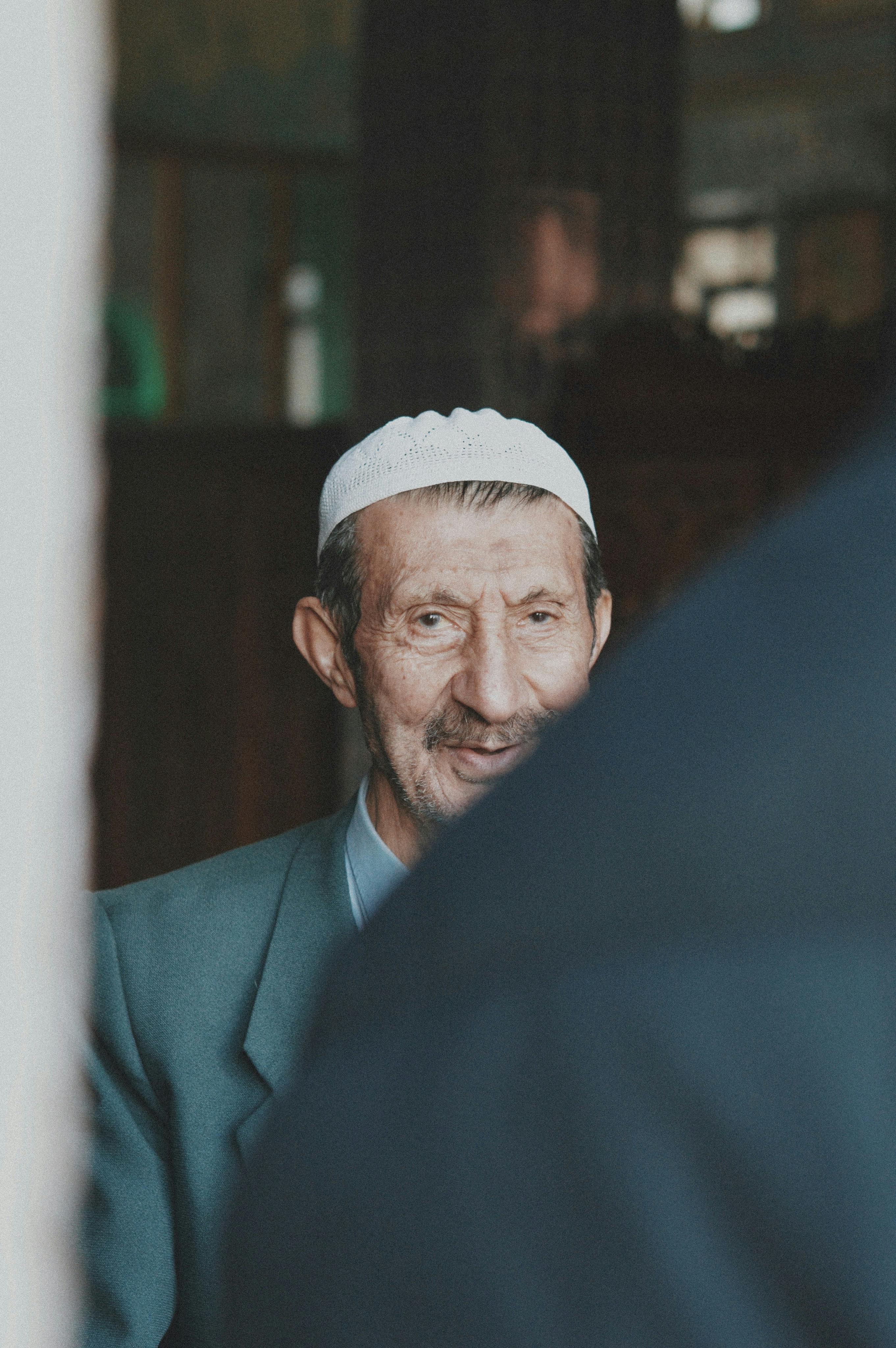 elderly man in hat and suit jacket