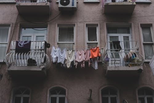 A balcony with clothes hanging on it and a balcony with clothes hanging on it