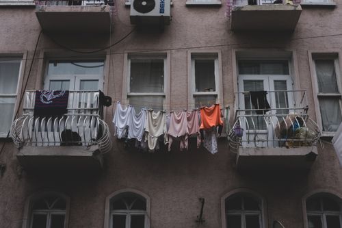 Free City apartment building with balconies and clothes drying outdoors. Captures urban residential life. Stock Photo