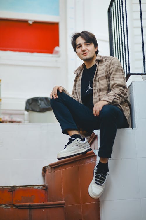 A man sitting on some stairs with his shoes on