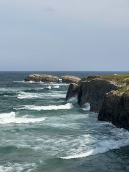 Dramatic coastal cliffs and crashing waves in Lugo, Spain, showcasing rugged natural beauty.